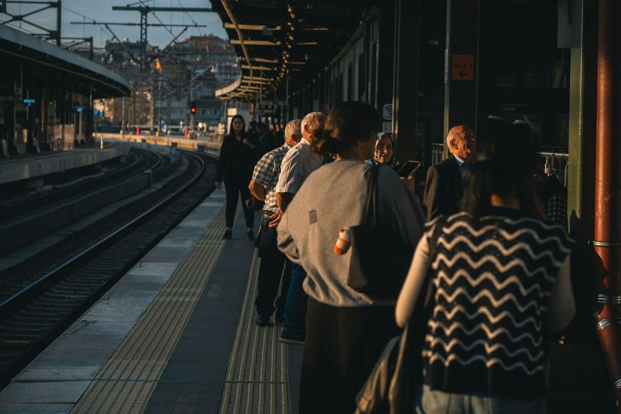 Passengers waiting on a station platform at golden hour