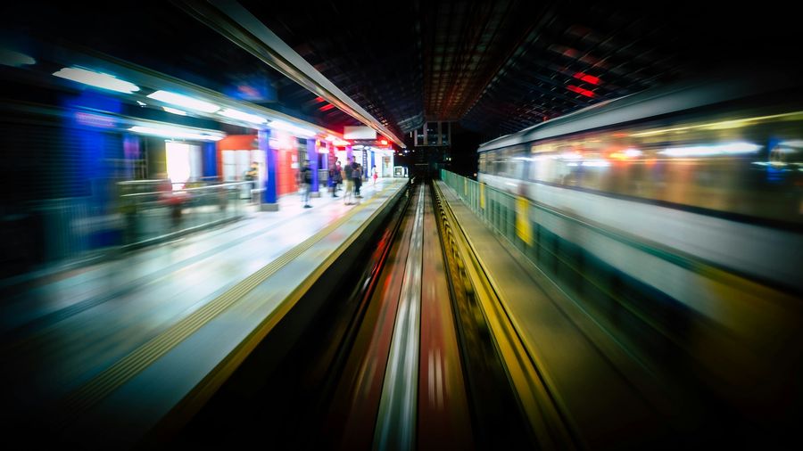 Motion-blurred elevated train speeding through a station