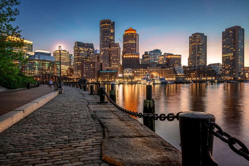Boston HarborWalk with the downtown skyline at dusk